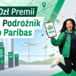 Dynamiczny baner reklamowy przedstawiający radosną kobietę w locie na tle terminala lotniczego. Trzyma ona smartfon z informacją o bonusie i model kuli ziemskiej. Po lewej stronie widoczne są duże, biało-zielone napisy: „Do 700zł Premii” oraz „Konto Podróżnik w Bnp Paribas”. Tło zdobią motywy mapy, kompasu i latające banknoty, a całość zachęca do skorzystania z promocji.